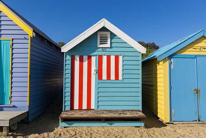 Colourful wooden Brighton Beach boxes along the beach on a lovely sunny day.