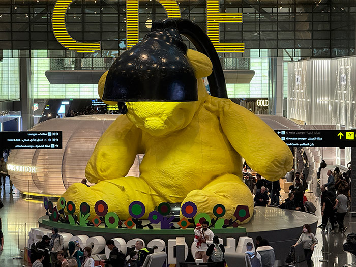 A giant yellow teddy bear and lap sculpture in Doha airport, Qatar