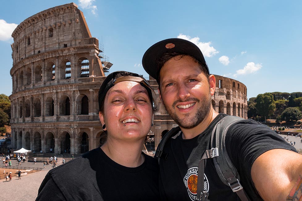 Nic and Shorty standing in front of the Colosseum in Rome, Italy.