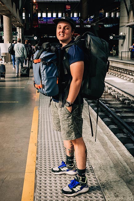 Nic waiting for a train with her backpacks on.