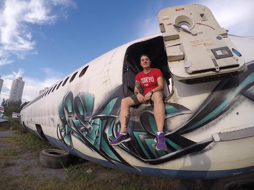 Nic sitting on the edge of an old airplane in Bangkok, Thailand