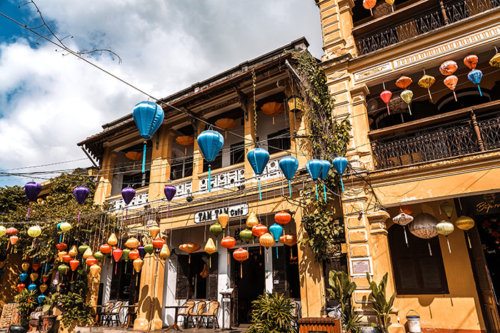 Yellow colonial buildings in Hoi An, Vietnam with colourful lanterns hanging across the street