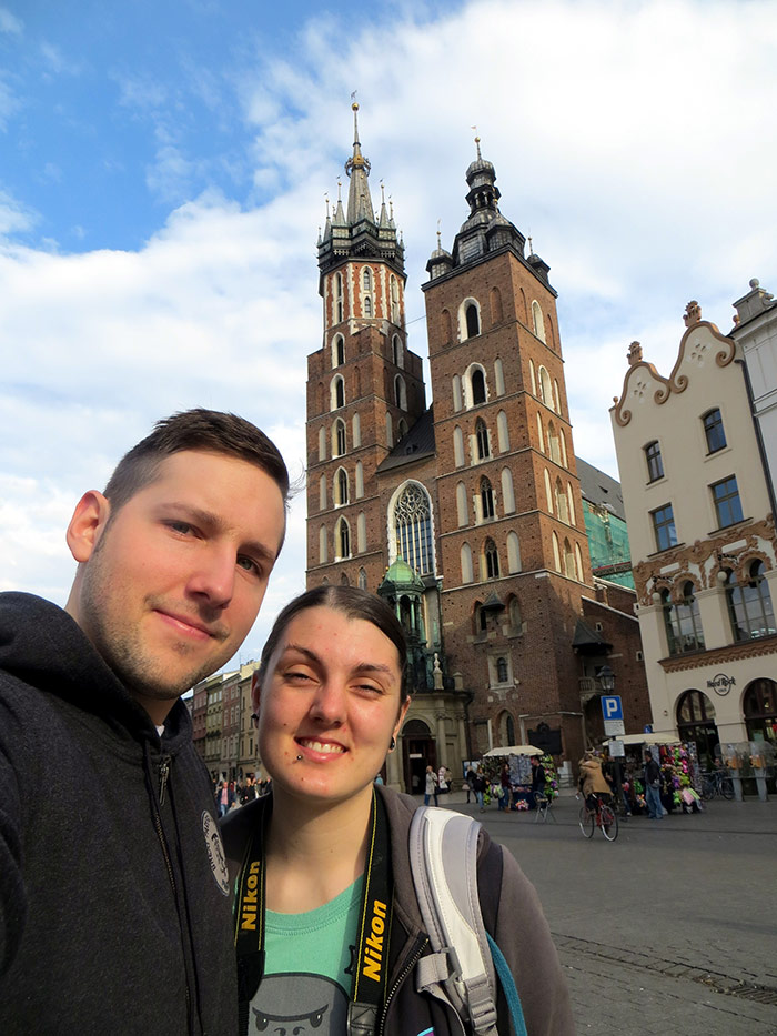 Nic and Shorty taking a selfie in Krakow, Poland with the main square and cathedral in the background
