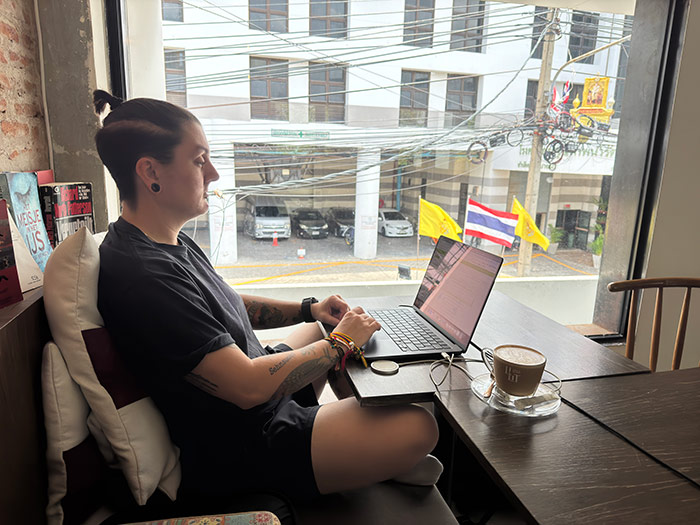 Nic working on a laptop in a cafe in Thailand