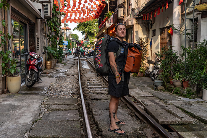 Nic stood on train street in Hanoi carrying their backpacks.