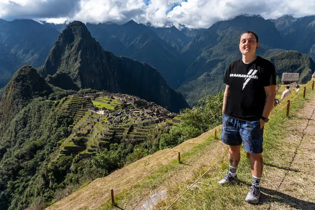 Nic standing on Circuit 1 at Machu Picchu in Peru, the classic view of the ruins can be seen behind them.