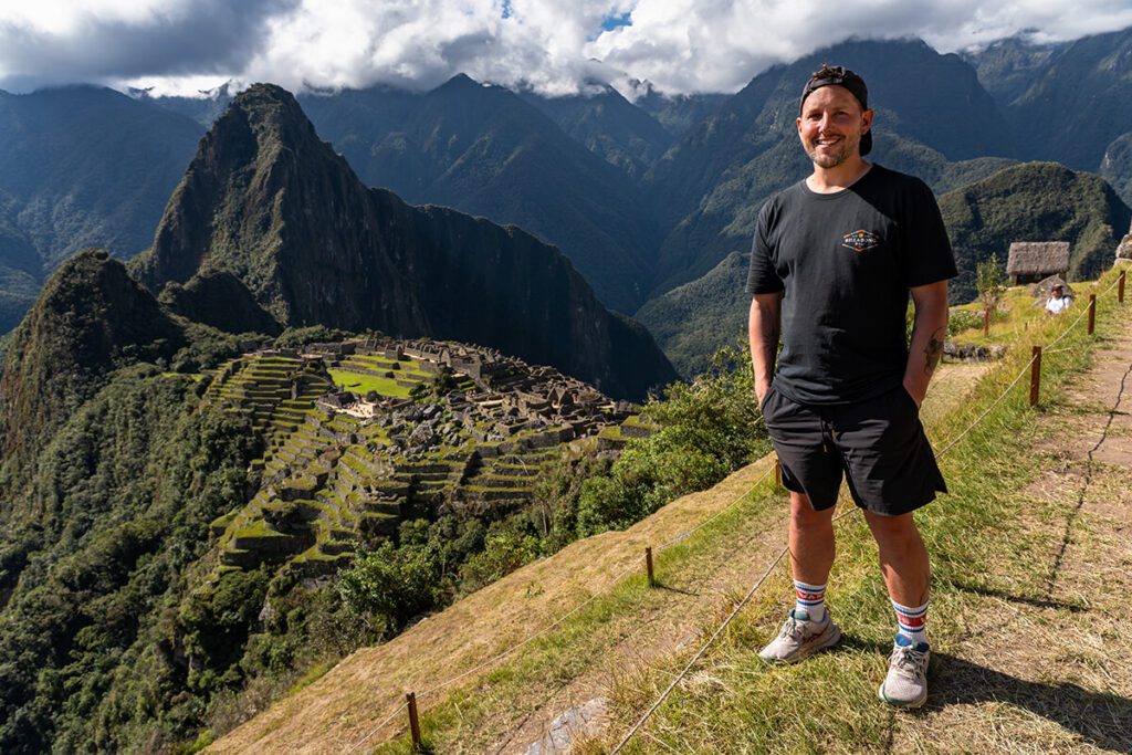 Shorty standing on Circuit 1 at Machu Picchu in Peru, the classic view of the ruins can be seen behind him